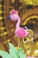 Flamingo Topper - Flamingo Dekoration und Nummer sechs Kerze auf einer Geburtstagstorte foto