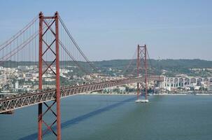 Lissabon, Portugal - - kann 10, 2023 - - das ponte 25 de Abril Brücke im Lissabon, Portugal, mit das Stadtbild im das Hintergrund foto