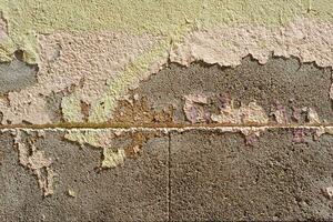 grau schmutzig Stein Mauer mit alt Peeling Stücke von Farbe und Gips foto