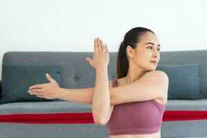 asiatisch jung gesund Frau im Sportartikel üben Yoga beim heim, Sport Mädchen meditieren im Leben Zimmer beim Zuhause foto