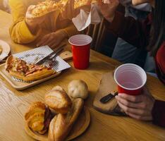 Gruppe von jung freunde Essen Pizza beim Zuhause und haben Spaß foto