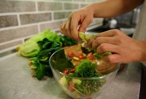 gesund Zutaten zum roh vegan Salat. Essen und Konzept von Veganismus, Kraft und gesund Essen. Nahansicht von weiblich Koch Hände vorbereiten roh vegan Salat beim Zuhause Küche. foto