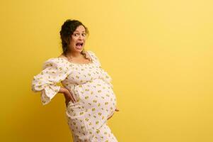 verblüfft schwanger Frau halten Bauch, Weinen und schreien suchen beim Kamera. einfach Lieferung, Schwangerschaft und Entbindung foto