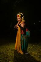 Porträt von ein indonesisch Tänzer mit ein Gold Gürtel Tanzen anmutig foto