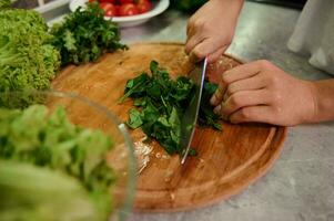 Kochen. Essen und Konzept von Veganismus, Kraft und gesund Essen - - schließen oben von weiblich Hand Schneiden Gemüse und Spinat Blätter zum Salat. gesund Zutaten zum roh vegan Salat foto