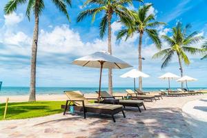 schöner tropischer Strand und Meer mit Sonnenschirm und Stuhl um den Pool im Hotelresort? foto