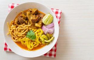 Nordthailändische Nudel-Curry-Suppe mit geschmortem Schweinefleisch
