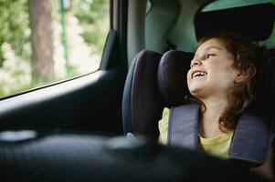 Sicherheit Ausflug durch Auto mit befestigt Kinder im das Booster Auto Sitz. bezaubernd Mädchen im das Kind Auto satt foto
