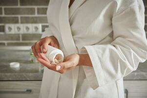 Nahansicht von Frau Gießen Tabletten von ein Container in Hand .medizinisch Thema, nehmen Vitamine, medizinisch Therapie. Konzepte foto