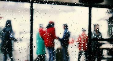 Regen fallen auf Fenster Glas von Kaffee Geschäft und verschwommen Stadt Leben Hintergrund. regnerisch Jahreszeit und verschwommen Menschen Stadt Tag Leben oder Bokeh Nacht Beleuchtung draußen Fenster. Kaffee Geschäft Fenster bedeckt mit Regen Wasser foto