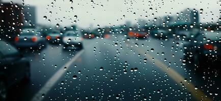 Regen Dusche auf Auto Windschutzscheibe oder Auto Fenster und verschwommen Straße im Hintergrund. foto