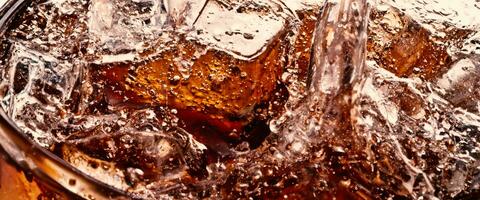 planschen von Cola und Eis. Cola Limonade und Eis planschen Sprudeln oder schwebend oben zu oben von Oberfläche. schließen oben von Eis im Cola Wasser. Textur von Karbonat trinken mit Luftblasen im Glas. kalt trinken Hintergrund foto