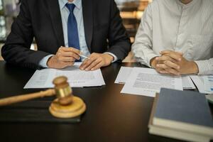 Anwalt legal Rat die Geschenke zu das Klient ein unterzeichnet Vertrag mit Hammer und legal Gesetz. Gerechtigkeit und Anwalt Geschäft Partnerschaft Treffen Konzept. foto