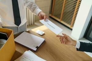 Verlassen Job Geschäft Mann Senden Rücktritt Brief und Verpackung Zeug zurücktreten drücken oder Tragen Geschäft Karton Box im Büro. Veränderung von Job oder gefeuert von Unternehmen. foto