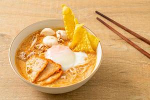 Reisfadennudeln mit Frikadellen, gebratenem Schweinefleisch und Ei in scharfer Suppe foto