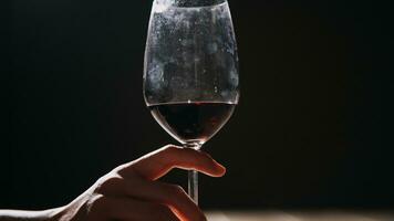Satz Hände, die Rotweinglas auf schwarzem Hintergrund isoliert halten. foto