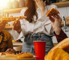 freunde aushängen. jung weiblich feiern Geburtstag Party beim Wochenende beim heim, Essen Pizza, Trinken Sekt, Party, Lebensstil, Freundschaft foto