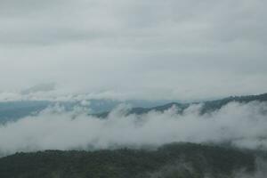 schön Panorama- Aussicht von Nebel und Wolken im entfernt Schichten Berge Angebot mit Blau Himmel im Morgen foto