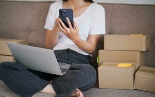 Geschäft von Zuhause asiatisch Frau vorbereiten Paket Lieferung Box Versand zum Einkaufen online. jung Start oben klein Geschäft Inhaber beim Zuhause online bestellen foto