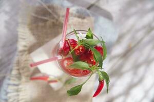 ein Glas gefüllt mit rot Pfeffer und ein Stroh foto