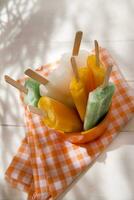 Eis Pops auf ein Teller mit Orange und Grün Streifen foto