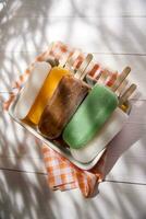 Eis Pops auf ein Teller mit Orange und Grün Streifen foto