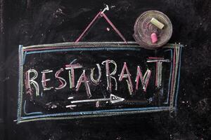 ein Tafel mit das Wort Restaurant geschrieben auf es foto