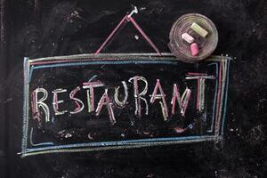 ein Tafel mit das Wort Restaurant geschrieben auf es foto