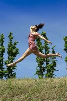 Mädchen Springen im Natur im Frühling Jahreszeit foto