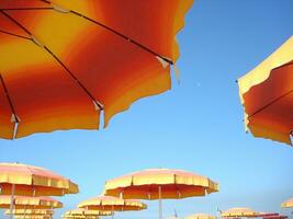 ein Reihe von Orange und Gelb Regenschirme foto