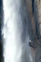 ein Person auf ein Seil Klettern oben ein Wasserfall foto