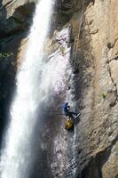 ein Person auf ein Seil Klettern oben ein Wasserfall foto