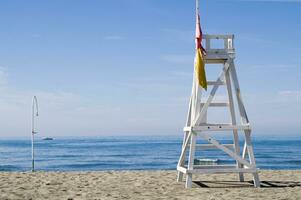 ein Rettungsschwimmer Stuhl Sitzung auf ein Strand foto