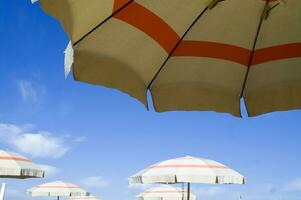 ein Strand Regenschirm mit ein gestreift Startseite foto