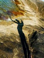 Schatten von zwei Menschen auf Felsen in der Nähe von Wasser foto