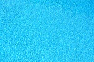 ein Blau Schwimmbad mit ein Sonne leuchtenden auf es foto
