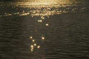 ein Boot ist im das Wasser beim Sonnenuntergang foto