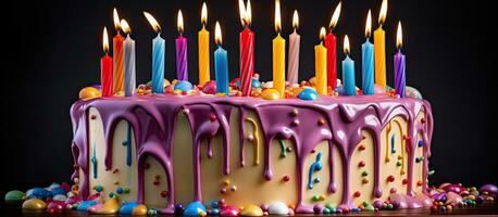 Regenbogen Geburtstag Kuchen geschmückt mit Kerzen im verschiedene Farben und dekorativ Glasur tropft Nieder foto