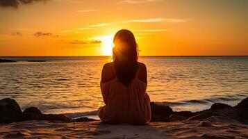 ein Frau sitzt auf das Strand Blick beim das romantisch Meer Sonnenuntergang foto
