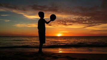 Junge s Silhouette auf Strand mit Ball foto