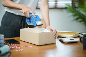 asiatisch Frau vorbereiten Paket Lieferung Box Versand zum Einkaufen online Lieferung Mail Bedienung Menschen und Sendung Konzept foto