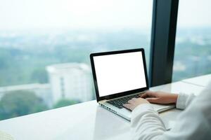 Frau Arbeiten durch mit Laptop leer Bildschirm Computer . Hände Tippen auf ein Tastaturtechnologie E-Commerce Konzept. foto