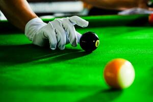 des Mannes Hand und Stichwort Arm spielen Snooker Spiel oder vorbereiten Zielen zu schießen Schwimmbad Bälle auf ein Grün Billard- Tisch. bunt Snooker Bälle auf Grün Fries. foto