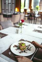 Luxus Tabelle die Einstellungen zum fein Essen serviert und dekoriert Tabelle mit Essen zum Gäste im das Restaurant foto