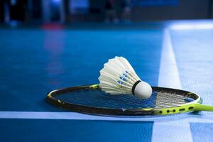 Badminton Federball und Schläger auf Blau Fußboden von Innen- Badminton Gericht, Sanft und selektiv Fokus. foto