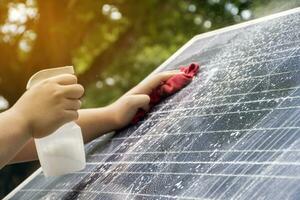 Reinigung Mini Solar- Panel im das Garten durch Sprühen Wasser und Waschmittel auf Oberer, höher Oberfläche und schrubben mit Sanft Stoff und dann Übergießen mit Wasser zu erhöhen, ansteigen das Effizienz von Solarzelle System. foto