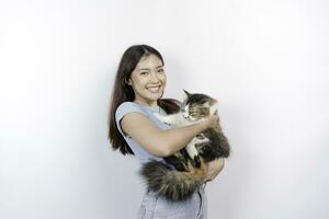 Porträt von jung asiatisch Frau halten süß Angora Katze mit Gelb Augen. weiblich umarmen ihr süß lange Haar Kitty isoliert durch Weiß Hintergrund. bezaubernd inländisch Haustier Konzept. foto