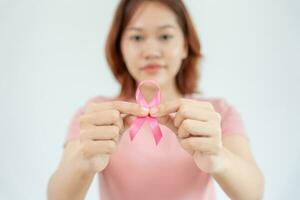 Frau hält Brustkrebsbewusstsein mit rosa Schleife. weibliches gesundheitscheckbewusstsein. Internationaler Frauentag und Weltkrebstag. zeichen krebs, symbolisch, gesundheitsversorgung, unterstützung von patienten, rechtzeitige diagnose foto