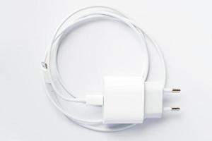 Draufsicht des schwarzen Telefon-Ladegeräts und des USB-Kabels auf weißem Hintergrund