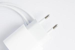 Draufsicht des schwarzen Telefon-Ladegeräts und des USB-Kabels auf weißem Hintergrund foto